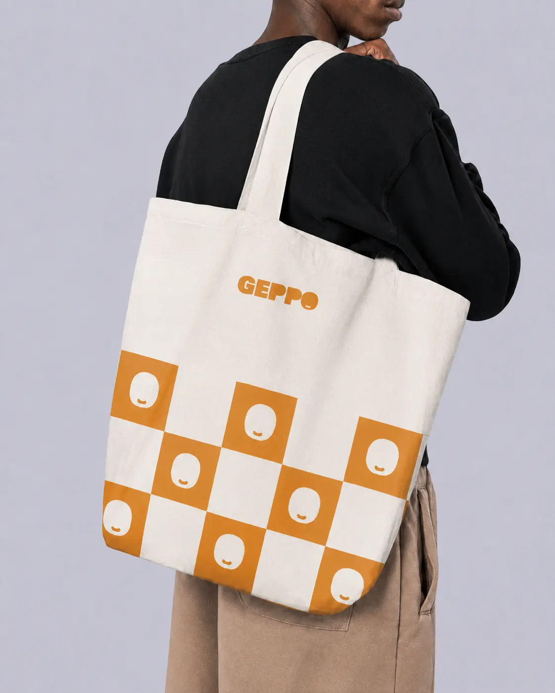 Borsa di tela con pattern a scacchi arancione e marchio Geppo, indossata