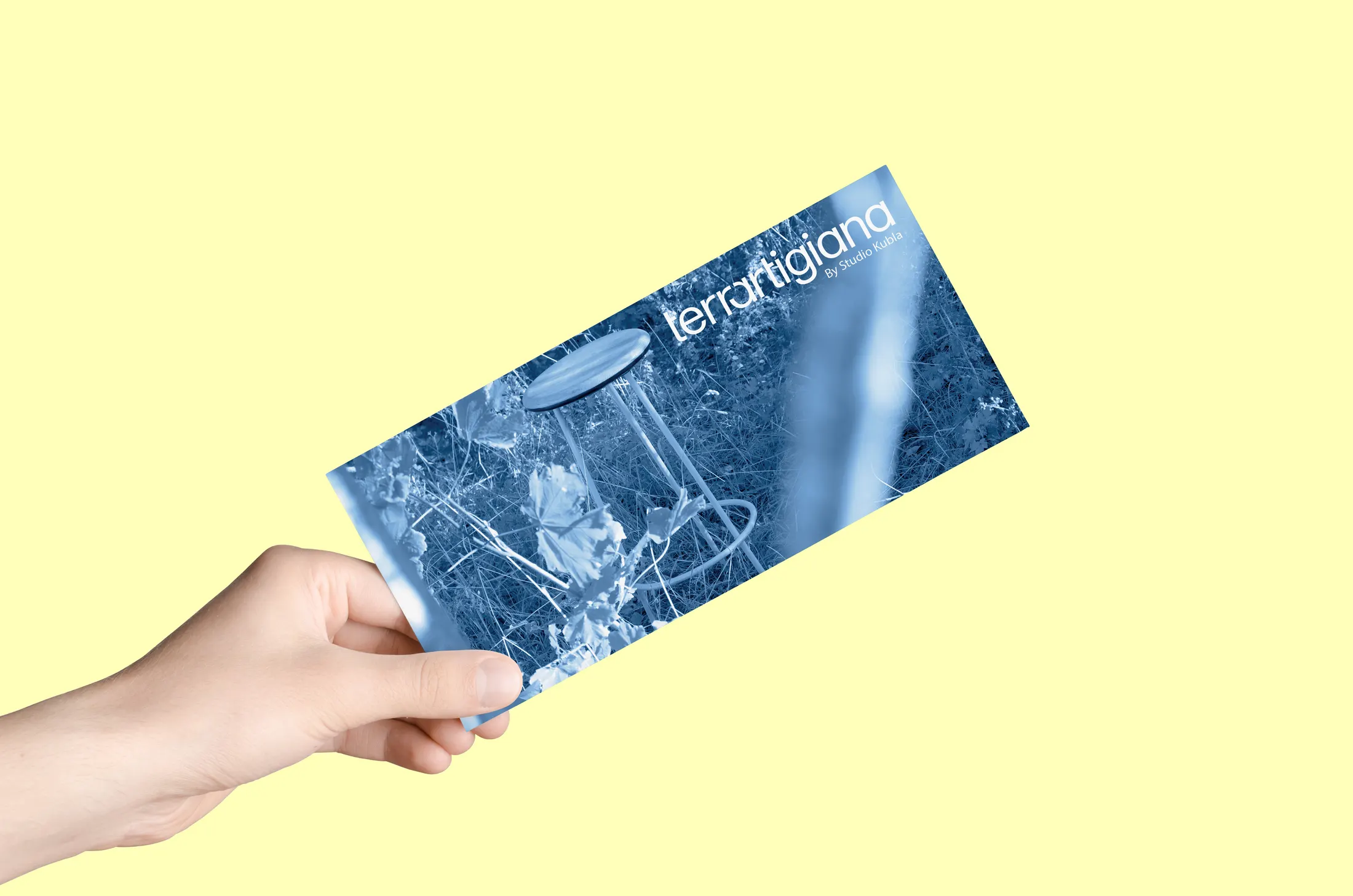 Mano che regge una cartolina del marchio su fondo giallo