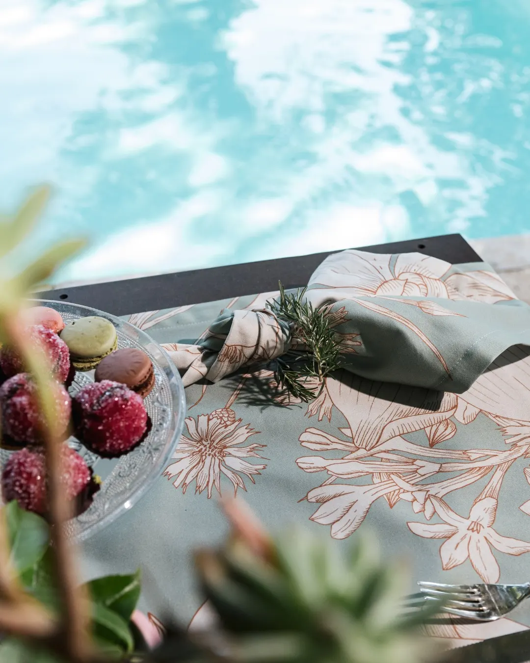 Tovaglia a fiori stesa accanto alla piscina, riflessi dell’acqua