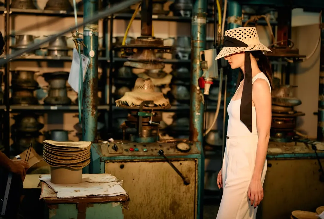 Immagine generata: figura di profilo col cappello fra le macchine del laboratorio