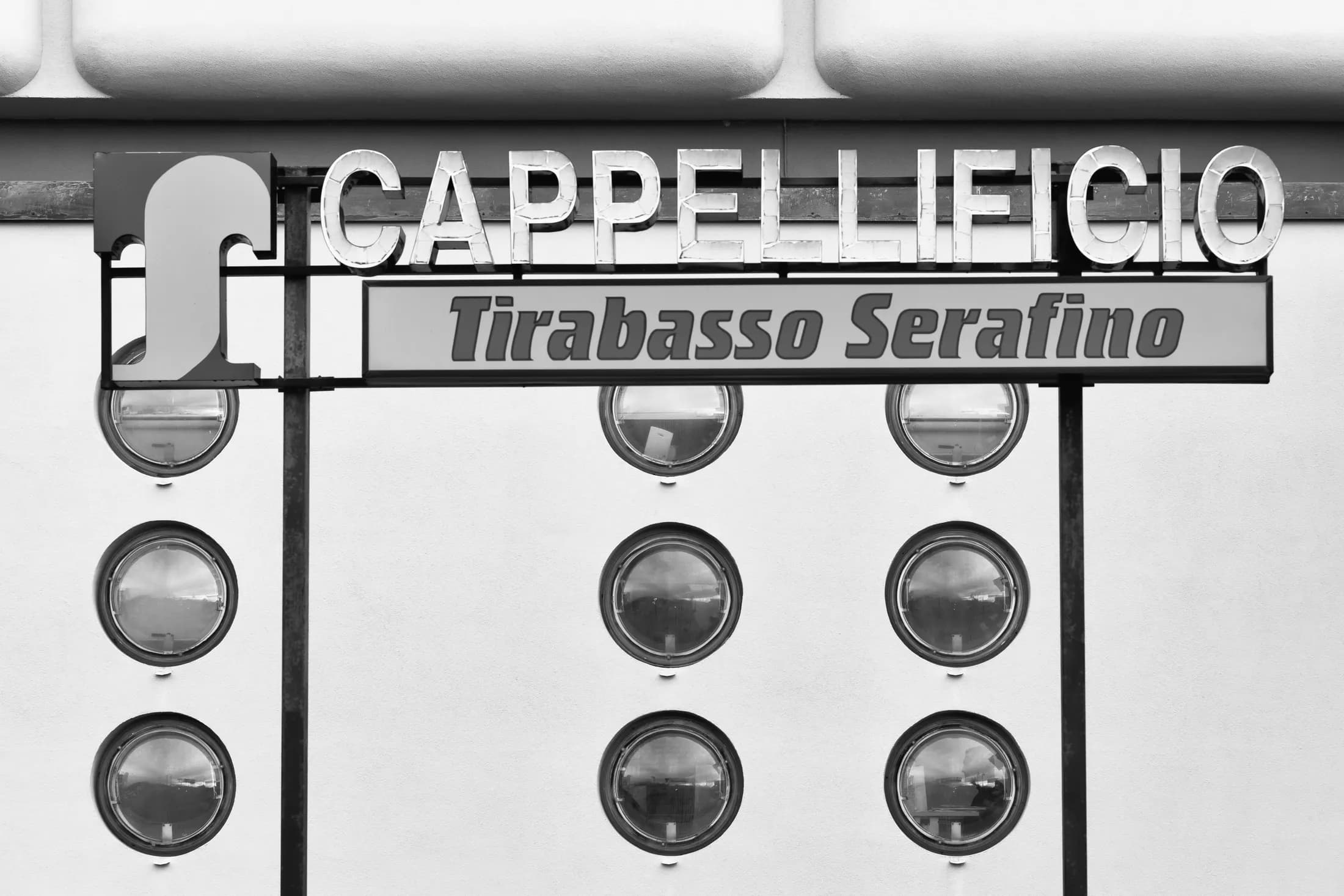 Insegna del cappellificio Tirabasso Serafino sopra i quadranti di una macchina